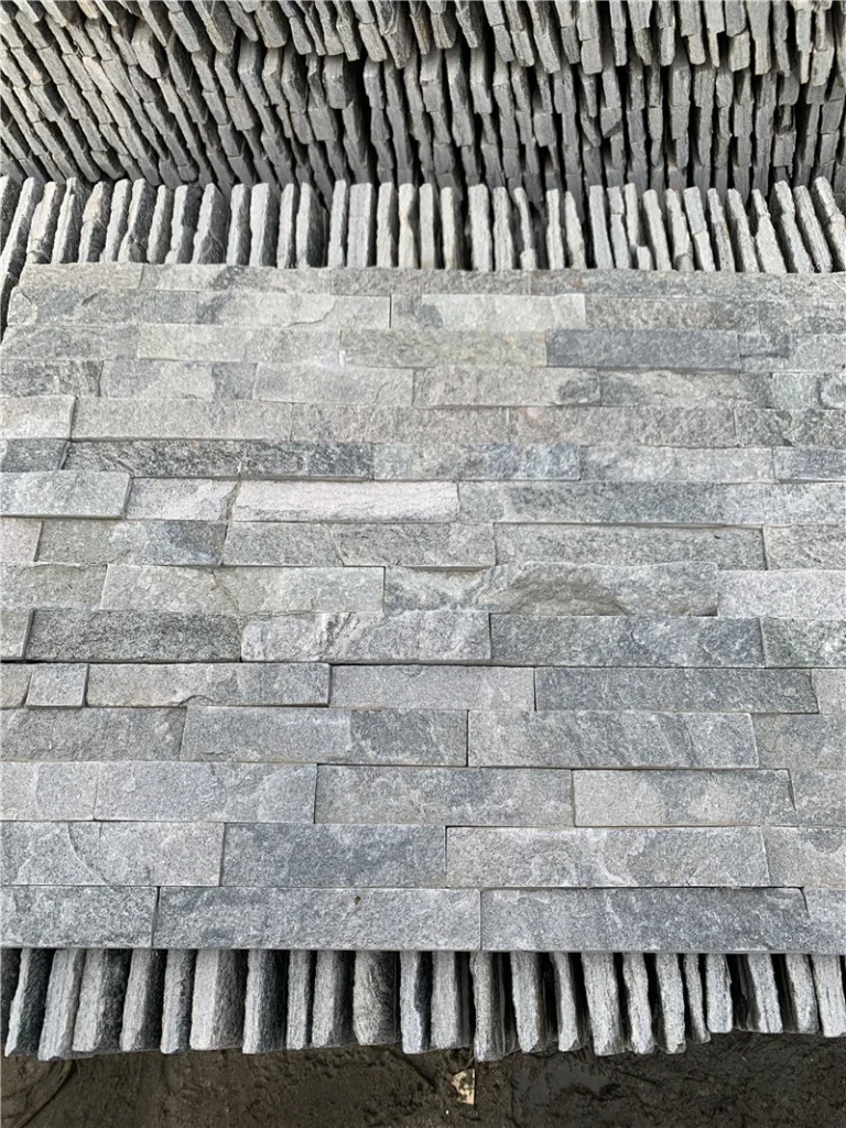 Pre-glued grey stacked ledger stone real installation on villa flat exterior wall with window