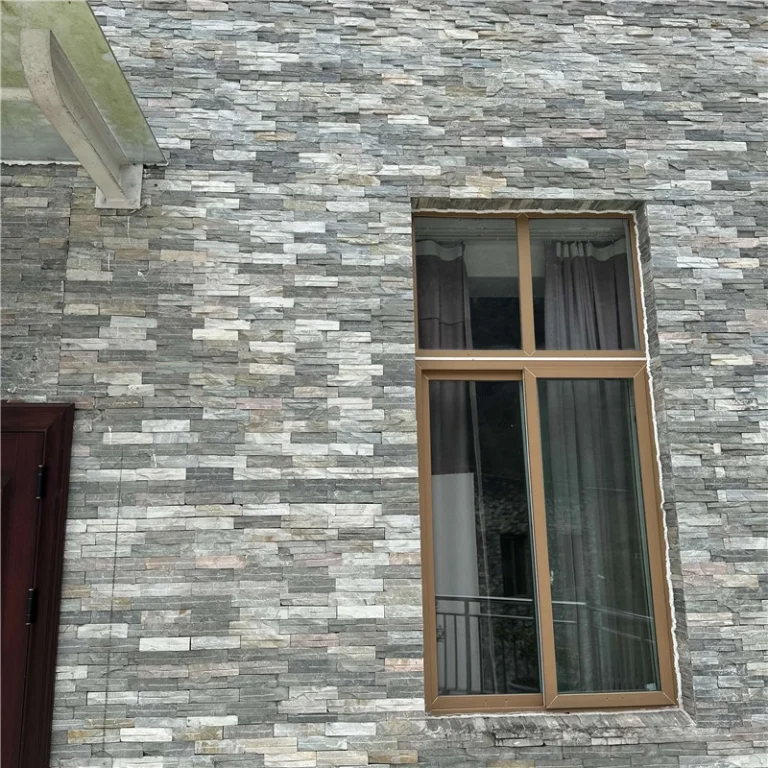 Grey pre-glued ledger stone veneer installed on flat residential exterior wall