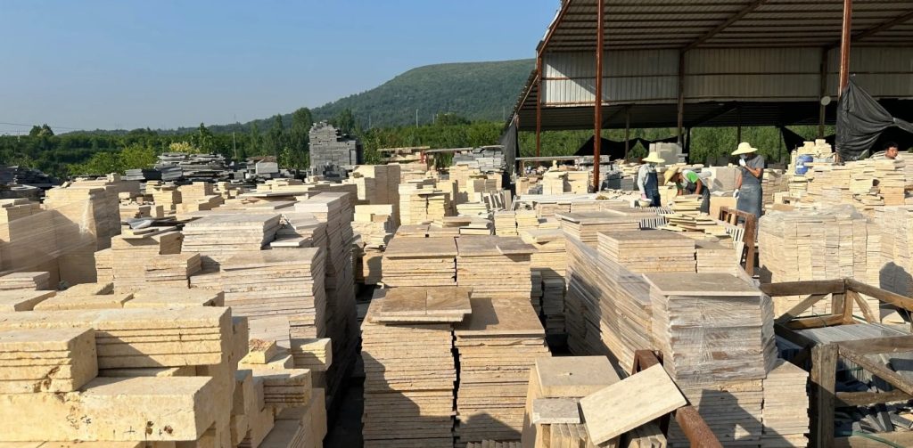 Hongmiao Stone outdoor stock yard stocked with natural limestone, split-face stone, random loose pavers & natural wall culture stone, abundant inventory for landscape architects and global construction buyers