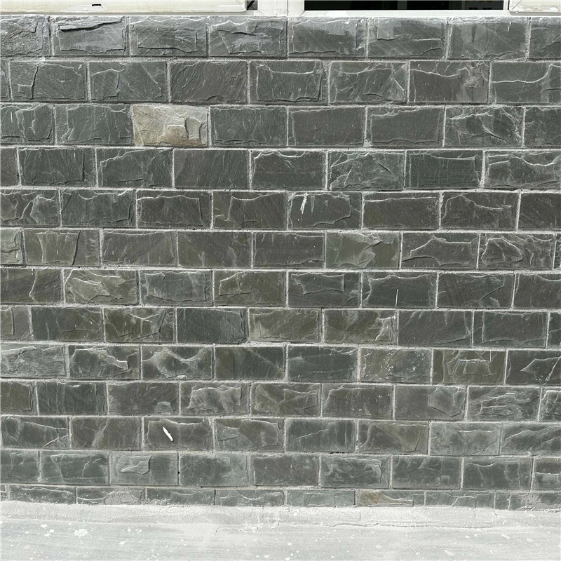 Finished exterior wall decorated with green slate mushroom culture stone