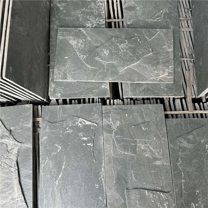 Close‑up layered texture of green slate mushroom‑faced stone panels
