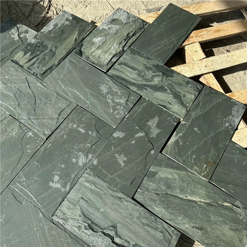 Natural green slate mushroom‑faced stone panels stacked on wooden pallets
