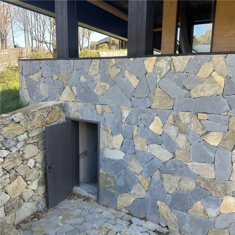 Grey‑blue crazy paving slate stone installed on exterior retaining wall, villa garden facade cladding project