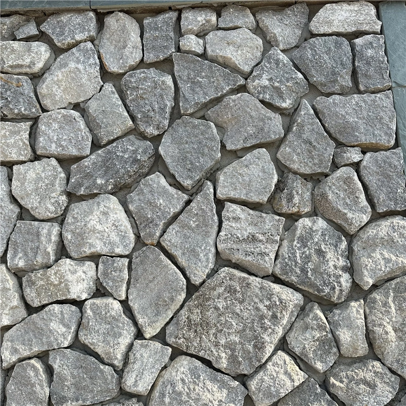 Close‑up view of grey‑white irregular crazy paving wall stone, natural split‑surface quartzite cladding texture