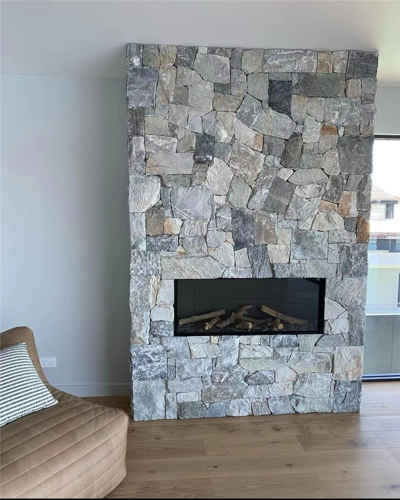 Indoor fireplace feature wall covered with grey‑white irregular crazy paving stone, natural random quartzite wall cladding