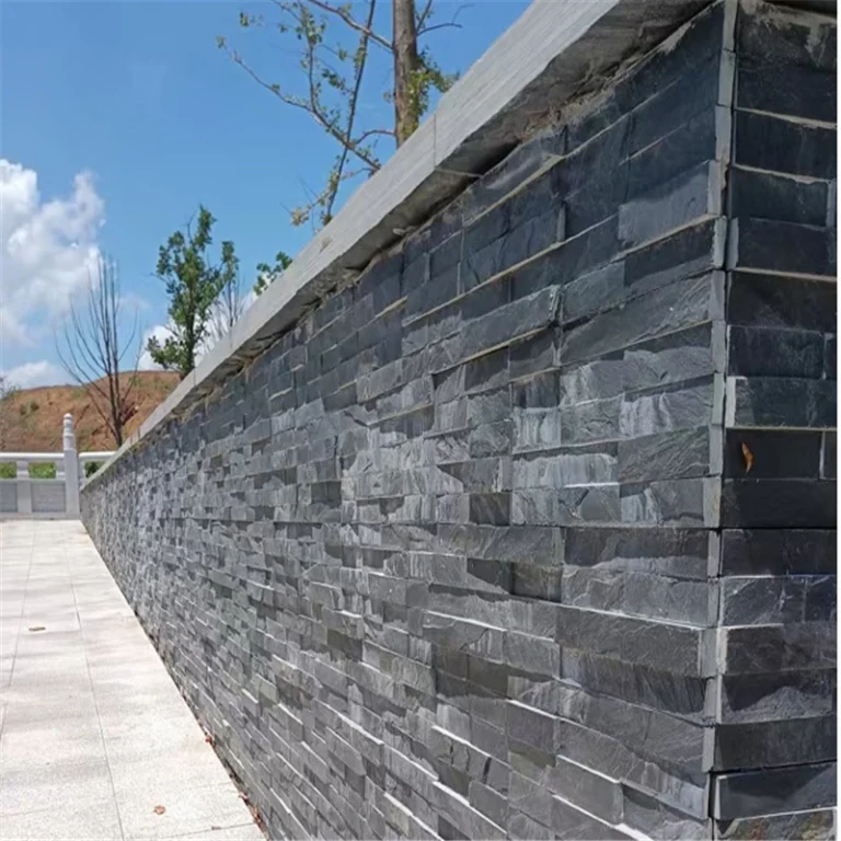 Black Stacked Stone Wall Cladding applied on outdoor landscape retaining wall