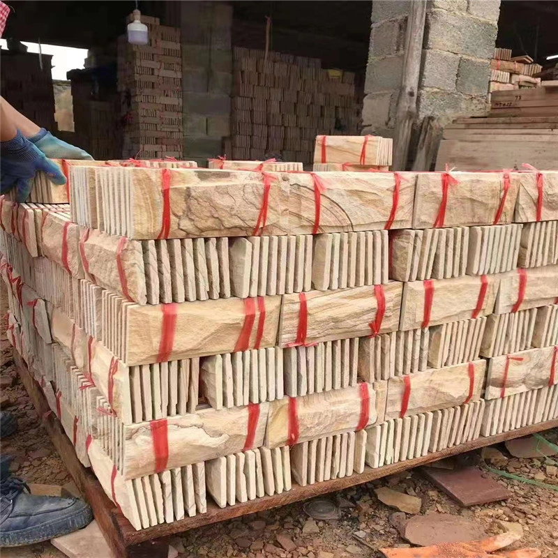 Bundled yellow sandstone rock‑face veneer panels stacked in stone factory for export shipment