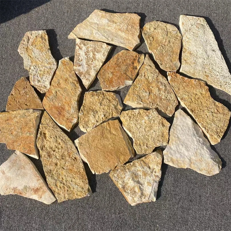 Bulk golden rust slate crazy paving loose stone pieces on ground
