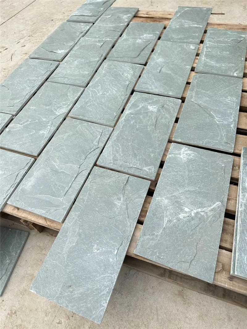 Green slate mushroom‑faced stone slabs neatly arranged on wooden pallets for export