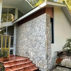 Metallic Grey Crazy Paving Stone veneer installed on residential house exterior wall