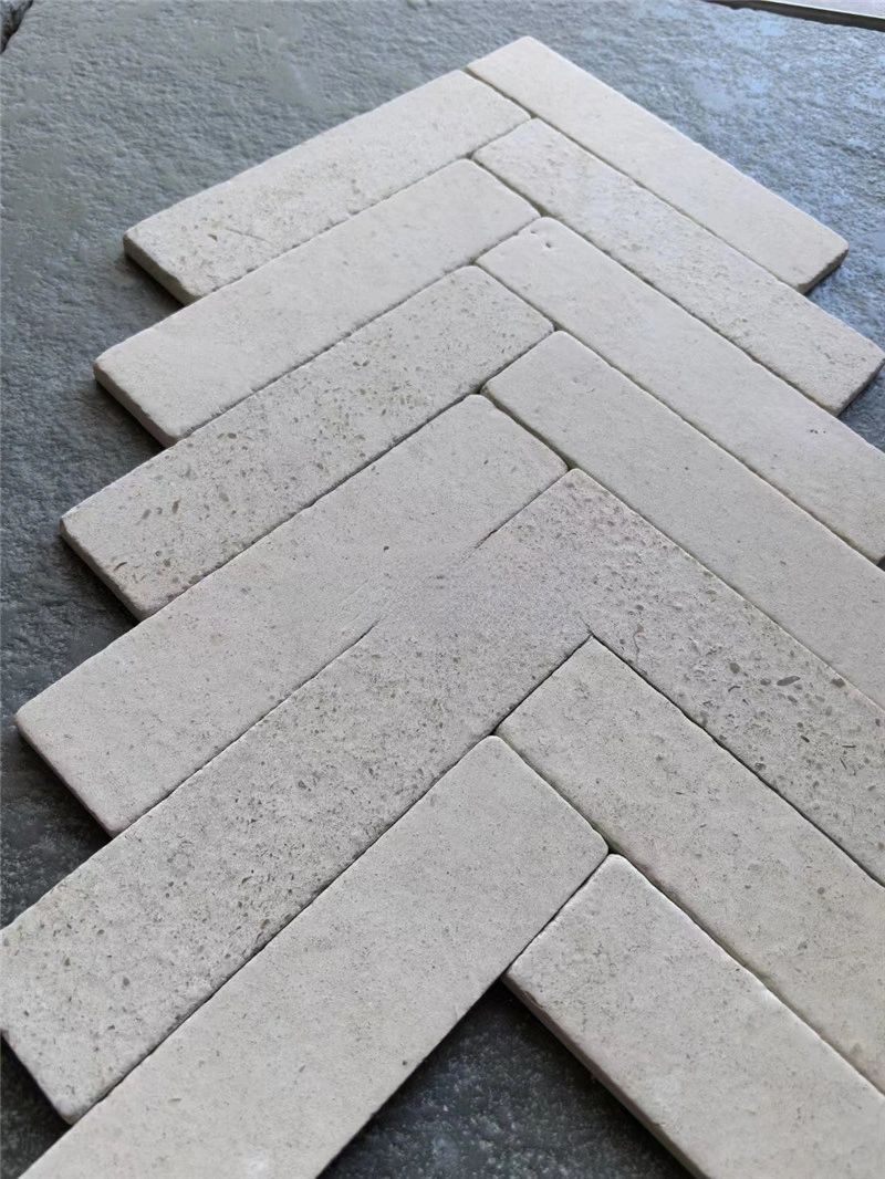 Herringbone beige travertine strip mosaic close‑up view natural stone tile