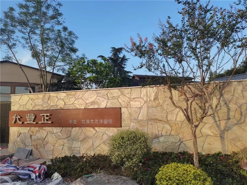 Golden rust slate crazy paving installed for exterior garden sign boundary wall
