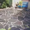 `Black slate crazy paving installed for outdoor garden patio flooring`