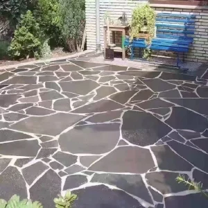 `Black slate crazy paving installed for outdoor garden patio flooring`