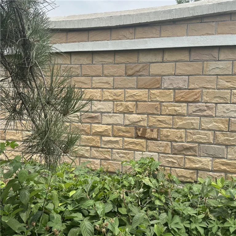Finished landscape wall with yellow sandstone rock-face cladding surrounded by green vegetation