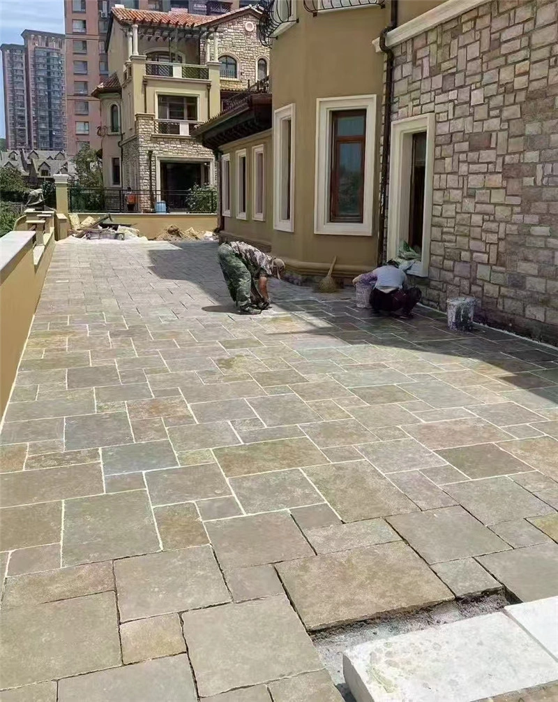 Yellow limestone multi‑size paving under installation for villa outdoor terrace