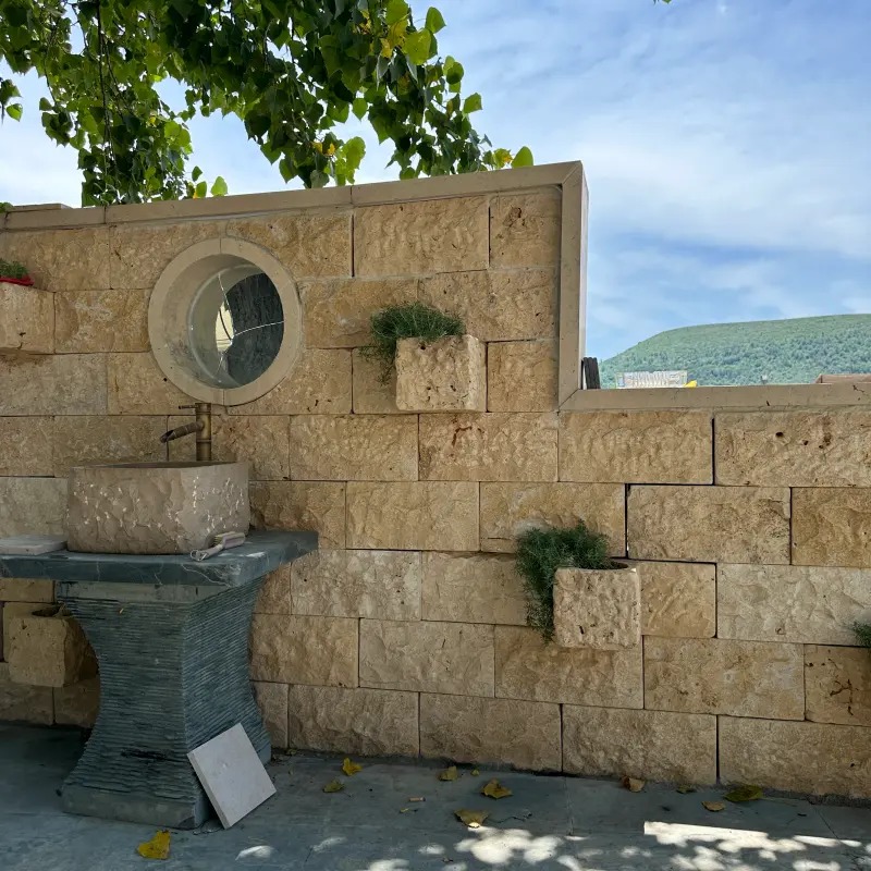 beige limestone ledger‑stone outdoor garden decorative wall with round window