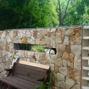 Golden Rust Random Fieldstone garden boundary wall with wooden bench