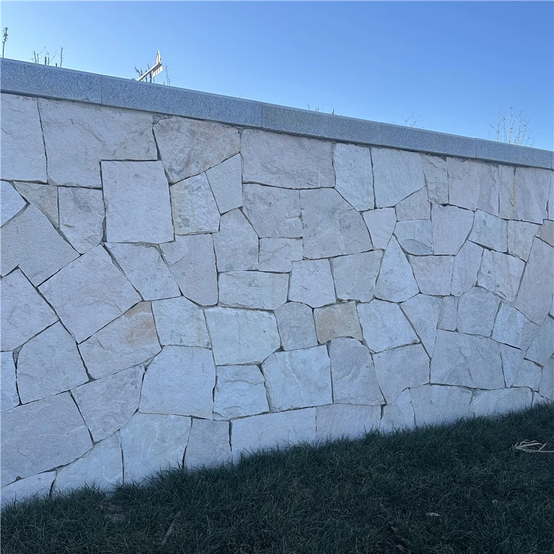Long outdoor garden wall cladded with white natural crazy paving wall stone