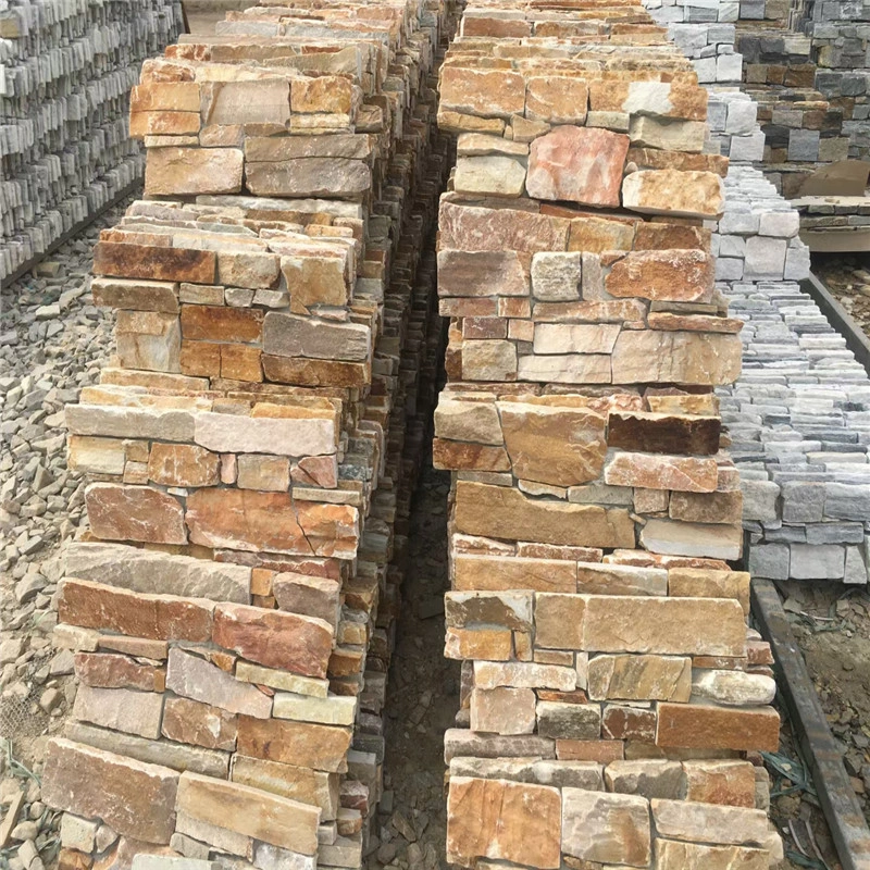 Rust colored natural stone ledger panels loose stock stacked in warehouse