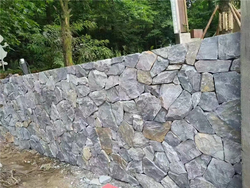 Grey irregular wall stone finished garden retaining wall