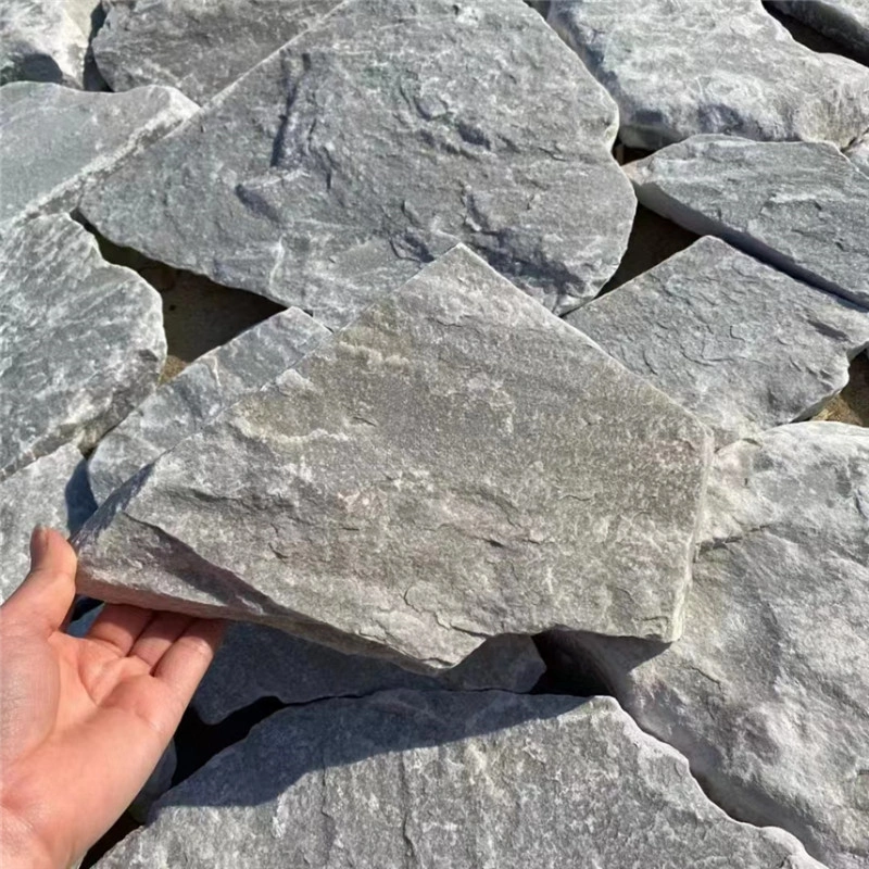 Natural grey irregular wall stone sample held in hand