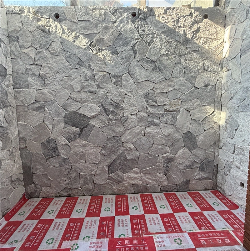 Grey White Random Stone Wall Cladding installation on exterior construction site