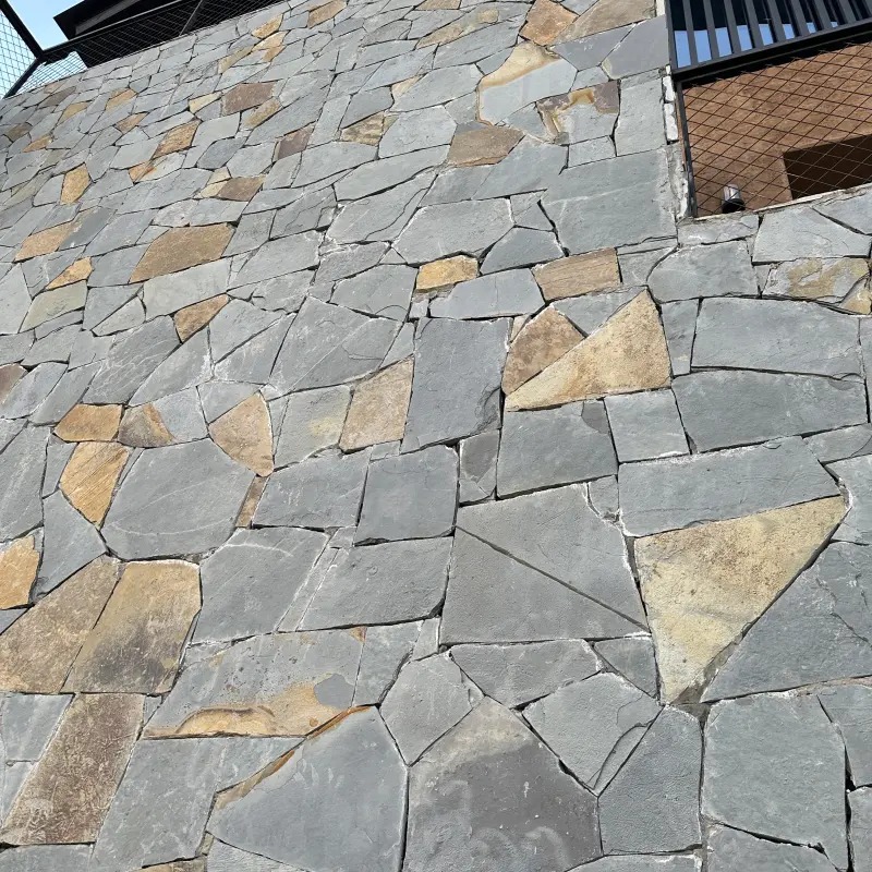 Grey crazy paving stone for villas, close-up view of irregular crazy paving stone on villa exterior facade